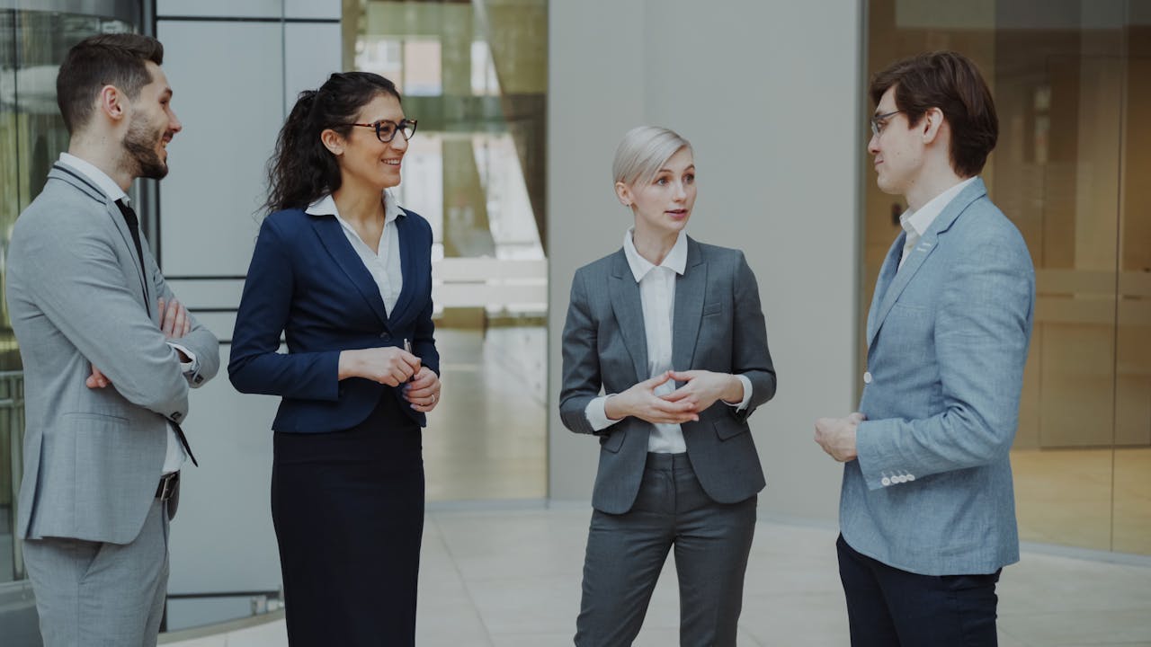 Group of diverse business professionals having a conversation in a modern office setting.