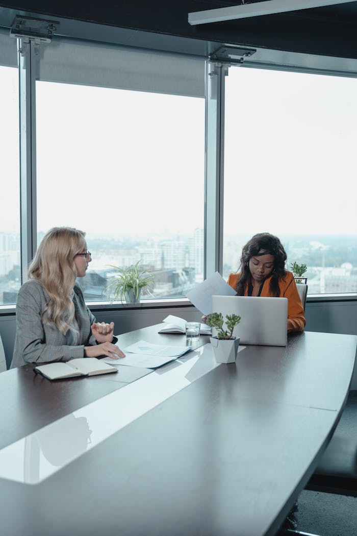 Professional women engaged in a meeting in a contemporary office setting.